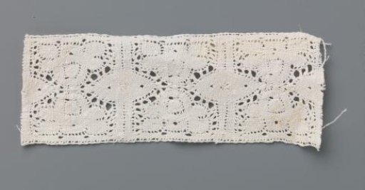 Strip of bobbin lace with two stylized mirrored flowers between vertical lines and ovals