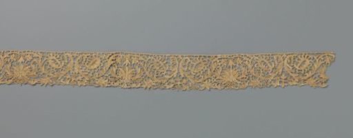 Strip of brown needle lace with an imperial-crown-shaped flower between acanthus leaves