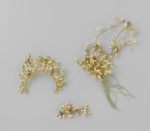 Bodice of orange blossom buds with green fabric stems from which a long stem with brass hangs