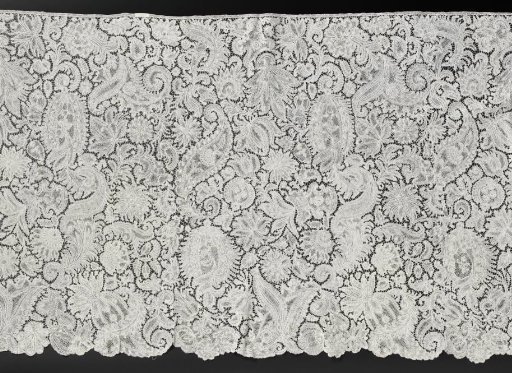 Ell strip of bobbin lace with feathered leaves and pineapples