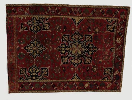 Star-Ushak or star medallion carpet. Crimson field with a stars-on-axes composition. Crimson border.