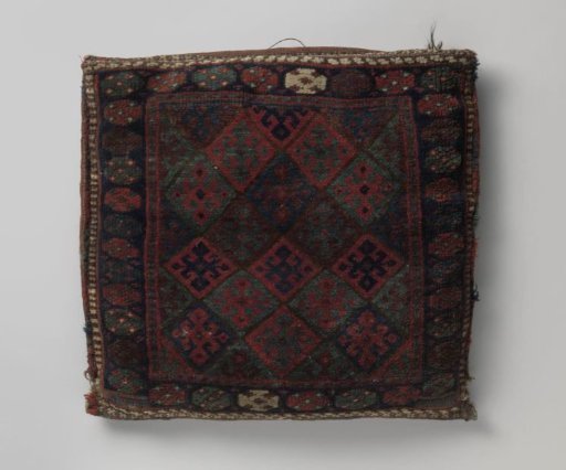 Cushion with a central pattern divided into squares featuring cross-flowers with hooks. Border with rosettes.