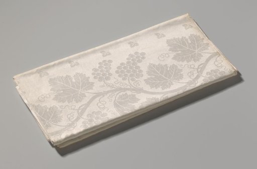 Tablecloth of white linen damask with a grape pattern