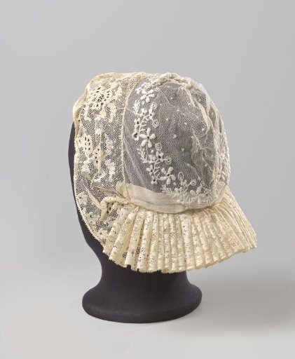 Tulle cap edged with Roeselare lace; the crown of tulle decorated with needlework is edged with a strip of Roeselare lace, pleated along the forehead