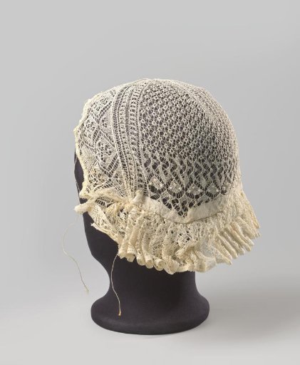 Cap of Frisian lace; the crown is edged with a strip, pleated along the forehead
