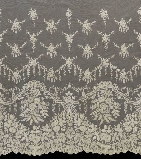 Overskirt of a wedding dress of appliqué lace with floral bouquets