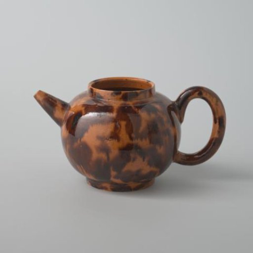 Teapot of earthenware with a yellow glaze and brown spots (De Caluwe kiln waste)