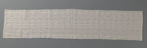 Strip of embroidered linen with open needle lace stitches, originating from a bedsheet and composed of several strips