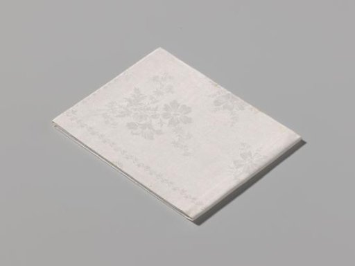 Napkin of white linen damask with a pattern of scattered flowers