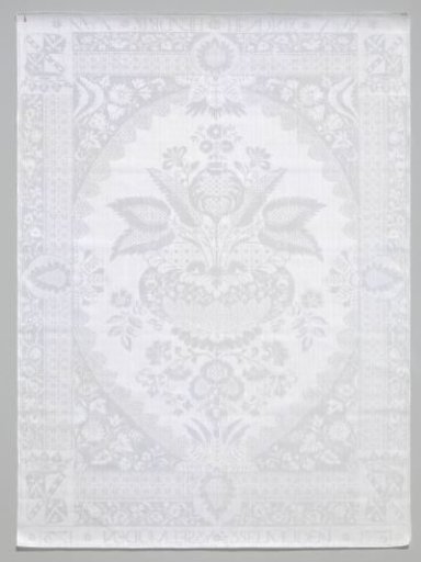 Napkin of white linen damask with a lace pattern and the name and coat of arms of Hendrik van Isselmuden and the year 1731 woven in