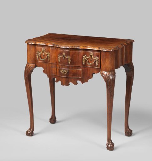 Tea table with a large and a small drawer, on four curved claw feet, decorated at the top with rocailles. Scalloped top with leaf and flower scrolls. Scalloped apron with gilded bronze mounts in the form of draped fabric