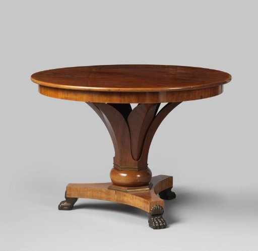 Table, round, of mahogany, resting on a hexagonal foot with bronze profiles at the bottom, consisting of a cup of six lancet-shaped leaves. Entirely resting on a triangular base with concave sides, on claw feet.