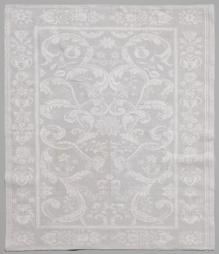 Tablecloth of linen damask with volutes with flowers, border with flower vases