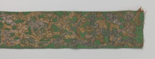 Strip of green silk with large flowers and leaves of silver lace and gold lace