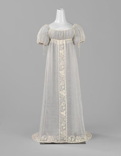 Jacket with high waist with ribbon, short sleeve and neck with cord of white transparent woven cotton; skirt with center panel and hem of white embroidered leaf vines and triangles