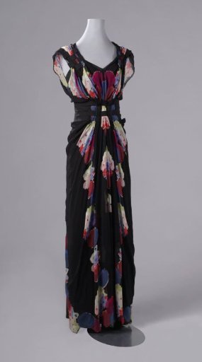 Skirt of an evening japon in slim model of black crêpe, with a panel on the right side of colorful flowers, fringed in some places; back with 13 fabric buttons
