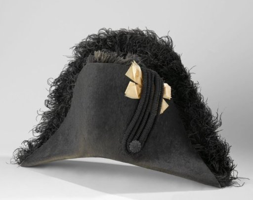 Round mourning badge of black hair felt, decorated with black ostrich feathers and a black bow over an orange ribbon