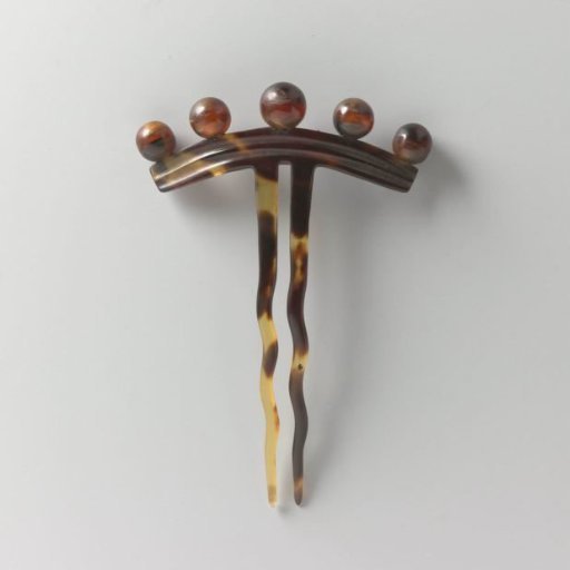 Hair comb of imitation tortoiseshell with a narrow back featuring five knobs and two twisted teeth
