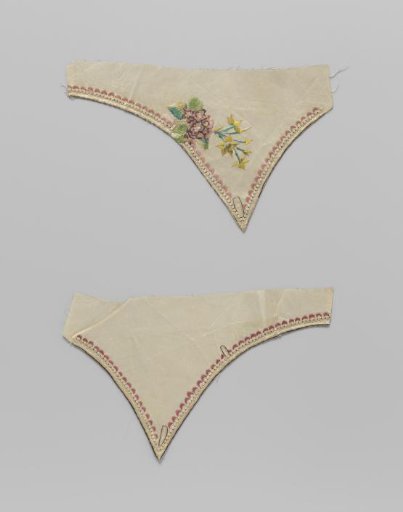Lapel of white taffeta with embroidered pearl border, pink shells and baby's breath with a tuft of jonquils
