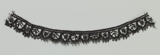 Strip of bobbin lace with arched border containing alternating leafy sprigs and roundels between spokes