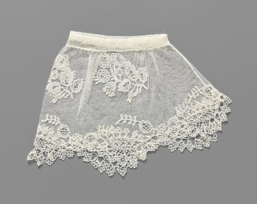 Cuff of appliqué lace with a radiating wreath of flowers around pointed ovals forming shells and two sprays of cluster roses