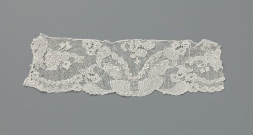 Strip of lace with V-shaped motif above folded shell