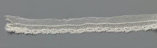 Strip of bobbin lace with border of openwork pointed ovals