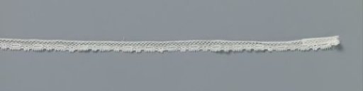 Strip of machine-made lace with a chain of small circles and pointed ovals along the lower edge