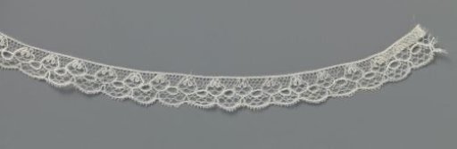 Strip of bobbin lace with a band of ovals and a row of truncated cones