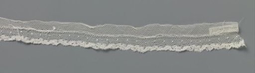 Strip of bobbin lace with S-shaped motifs along the lower edge