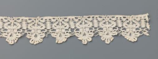 Strip of bobbin lace with palmette flower in heart-shaped vase
