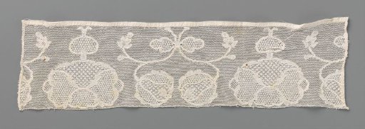 Strip of bobbin lace with facing round flowers with a bow