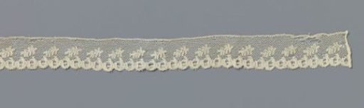 Strip of bobbin lace with obliquely placed feather-shaped leaves