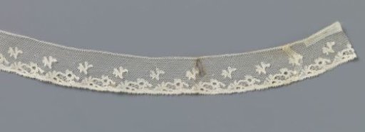 Strip of bobbin lace with V-shaped leaves and flowers directed to one side
