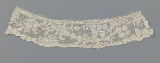 Strip of bobbin lace with a pearl necklace in a compound vine