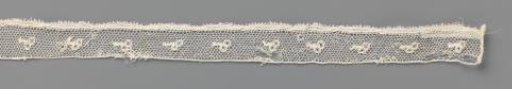 Strip of bobbin lace with two berries on a short twig