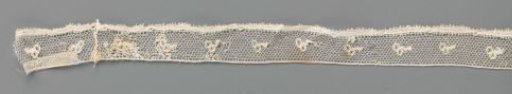 Strip of bobbin lace with two berries on a short branch