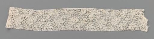 Strip of bobbin lace with a wave of a fan-shaped flower and feathered leaf
