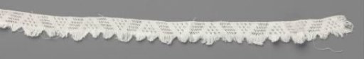 Strip of lace fabric with triangles and triangular fringe shells
