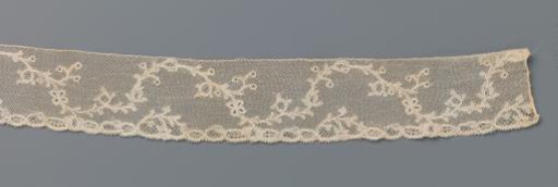 Strip of bobbin lace with a continuous wavy vine with berries and a butterfly