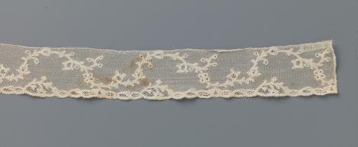 Strip of bobbin lace with a continuous wavy vine with berries and a butterfly