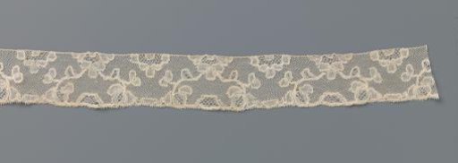 Strip of bobbin lace with halved flowers and bows of flower branches