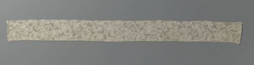 Strip of mixed lace with a wavy ribbon to which various flowers and leaves are attached