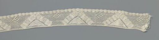 Strip of bobbin lace with V-shaped motifs above a fan-edge border