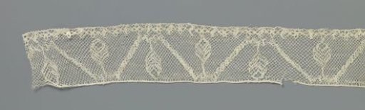 Strip of bobbin lace with tree between zigzag line