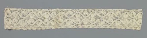 Strip of bobbin lace with fan-shaped leaves between wavy lines
