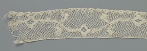 Strip of bobbin lace with diamond-shaped rosette flowers on a wavy vine