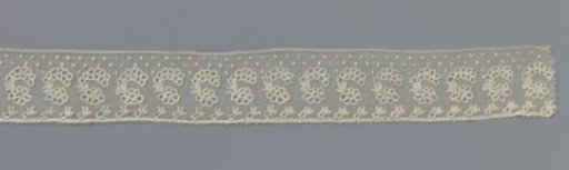 Strip of bobbin lace with C-shaped motif made with circles