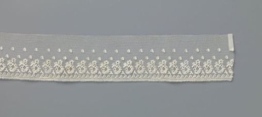 Strip of tulle bobbin net with applied picot edge, decorated with a running pattern of one-sided waving oval leaves growing from grass shoots