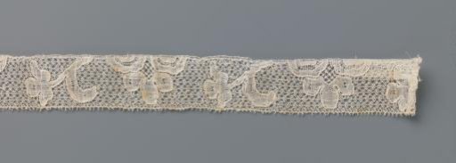 Strip of bobbin lace with three-lobed flower and obliquely directed flower sprig